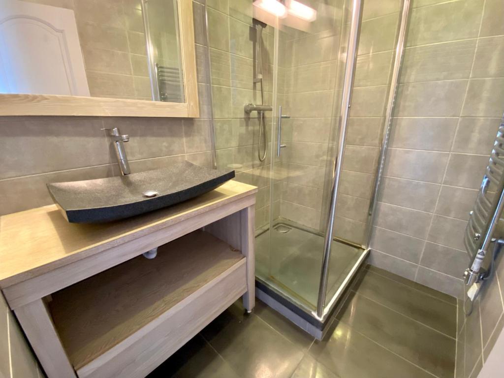 Salle d'eau avec douche à l'italienne, vasque en pierre et meuble bois