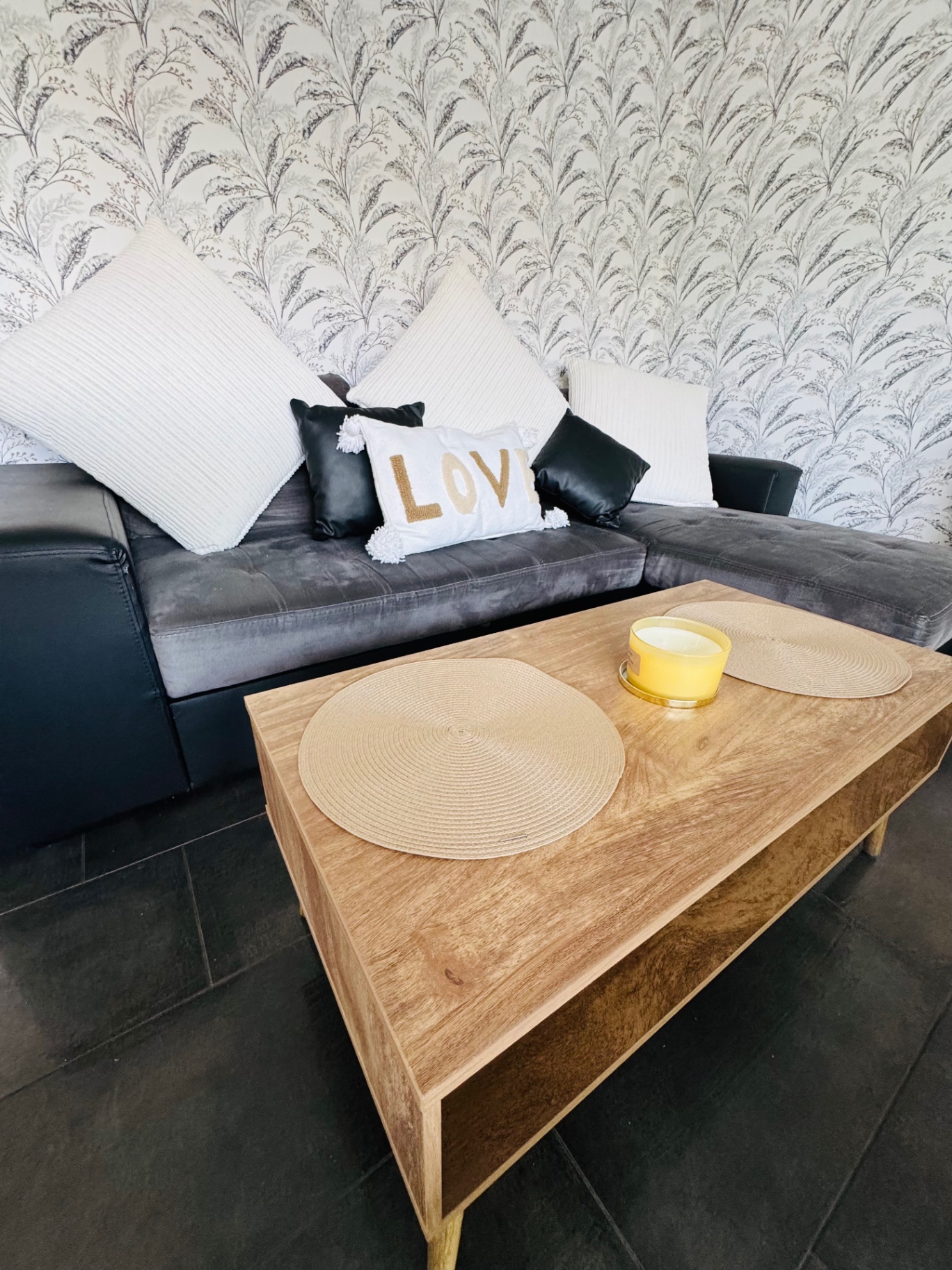 Canapé d'angle gris avec coussins et table basse en bois