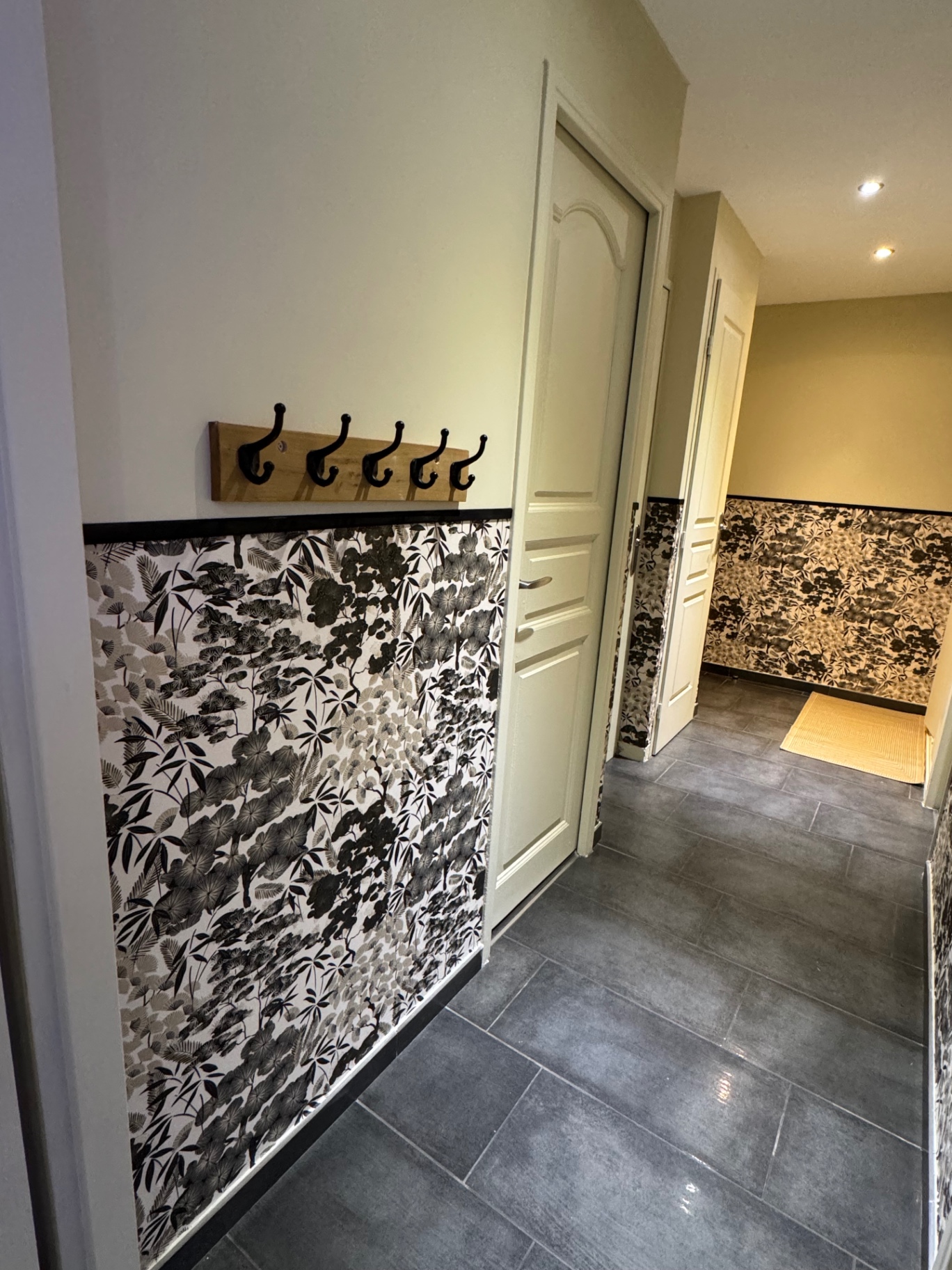 Entrée avec porte-manteaux en bois et papier peint noir et blanc