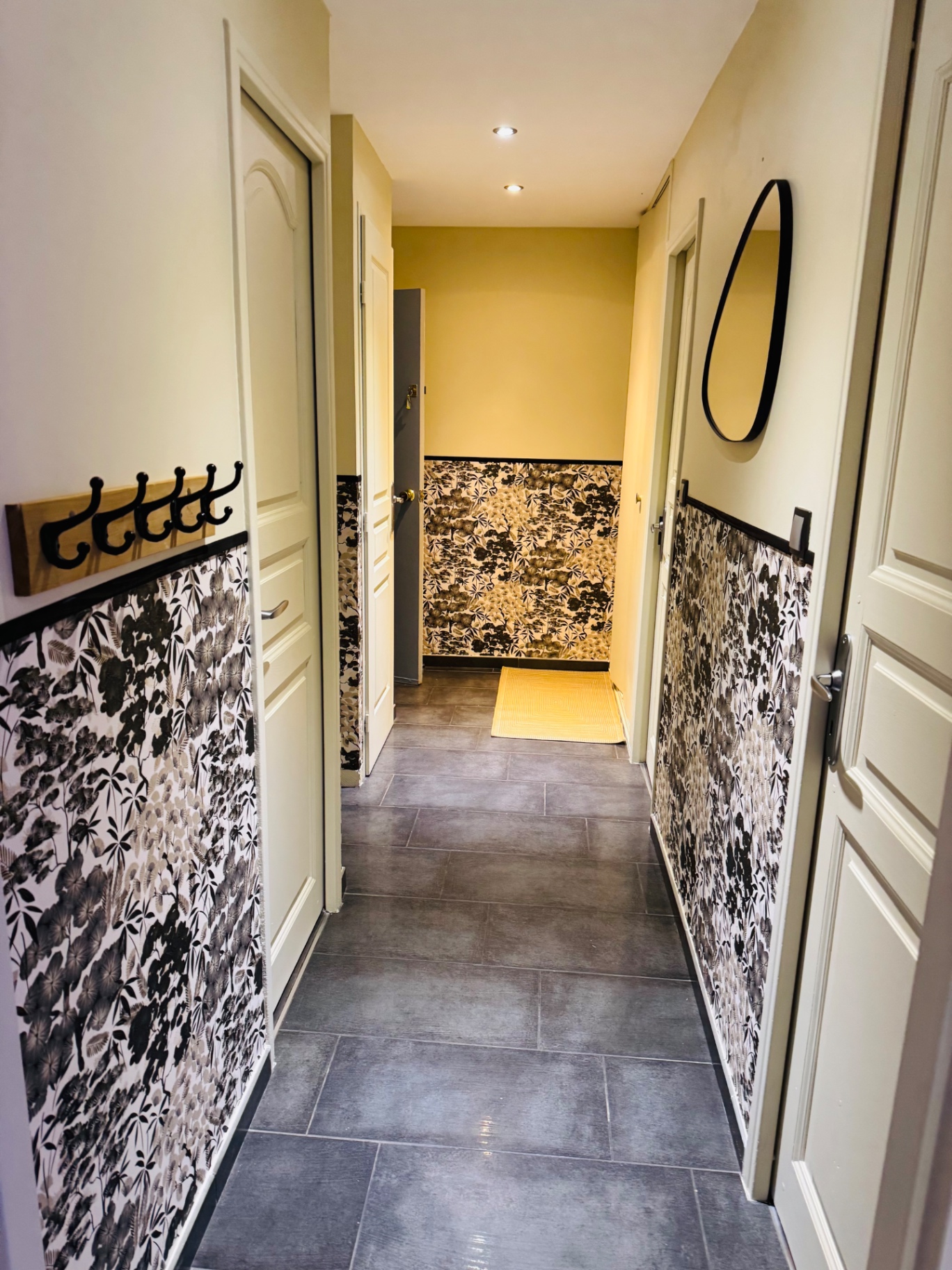 Couloir de l'appartement avec papier peint végétal et miroir