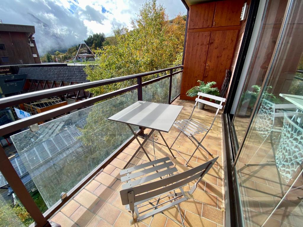 Balcon aménagé avec table et chaises, vue sur la station en été