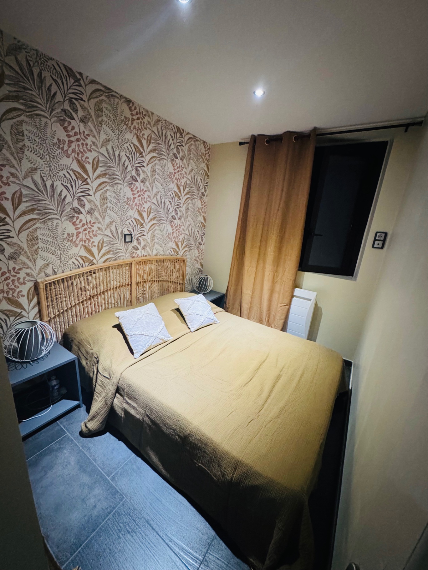 Chambre avec lit double 140 cm, tête de lit en rotin et papier peint végétal